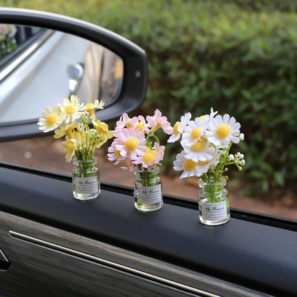 Car dashboard daisy flower decoration trio in glass vials with white, yellow, and pink flowers