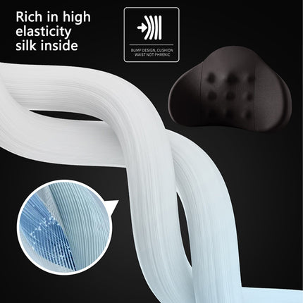 Black lumbar support pillow with tufted dimples next to white elastic roll