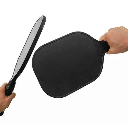 Black pickleball paddle with textured handle grip held in a hand